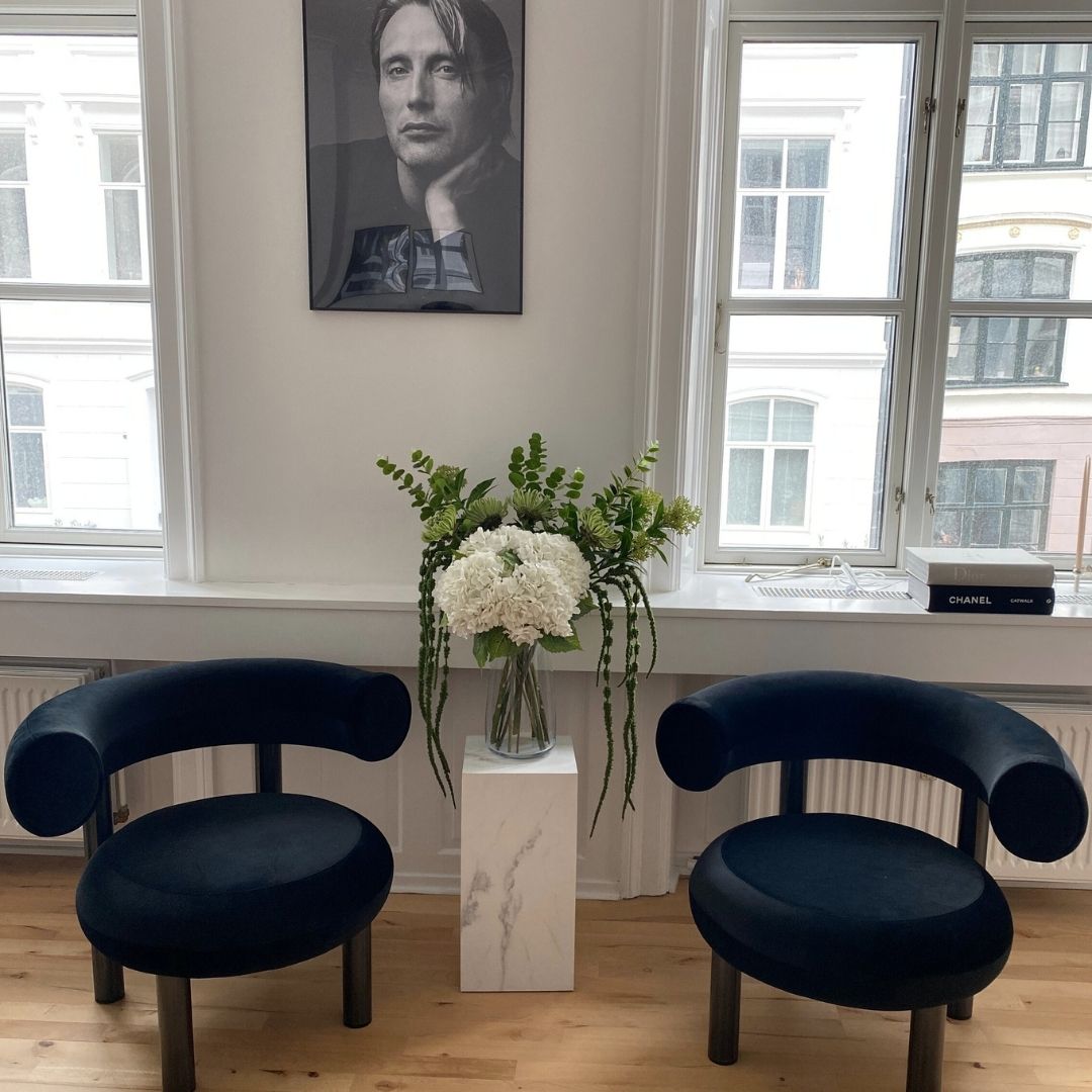 Afrundet loungestol i sort velour til moderne stue eller loungeområde