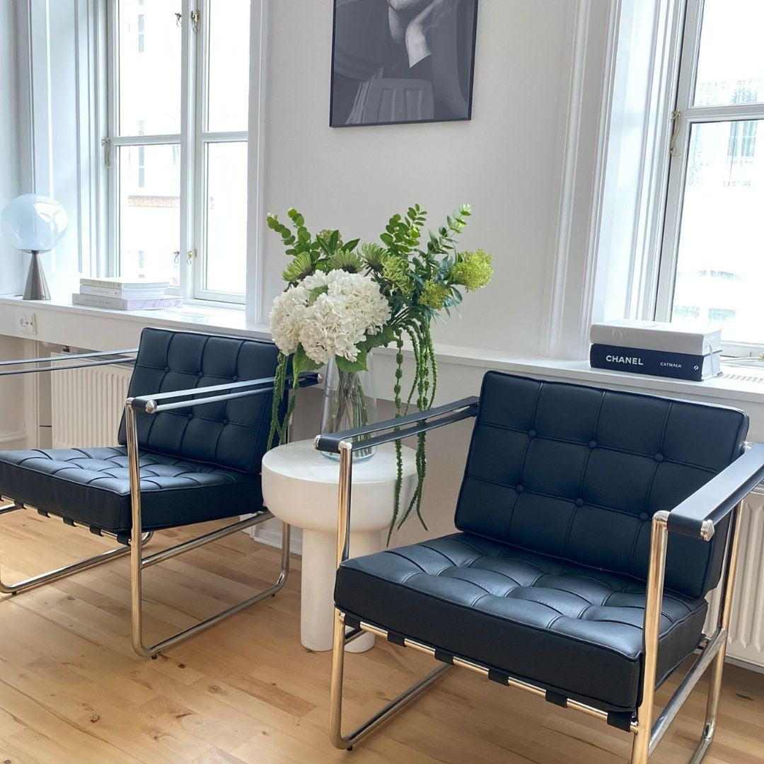 Eksklusiv design loungestol i sort læder med stålstel og armlæn