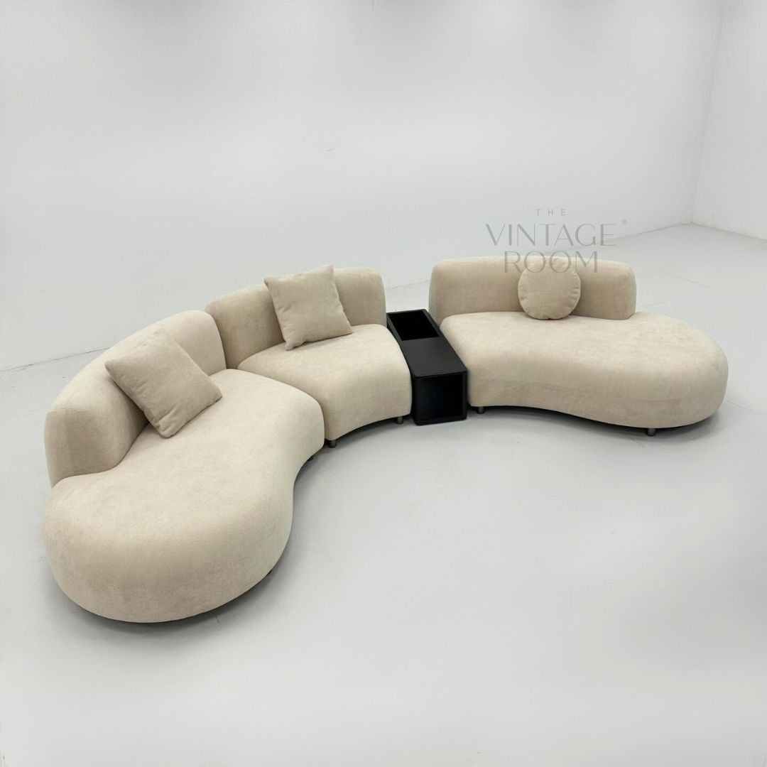 Buet modulsofa i lyst stof med integreret sort sidebord