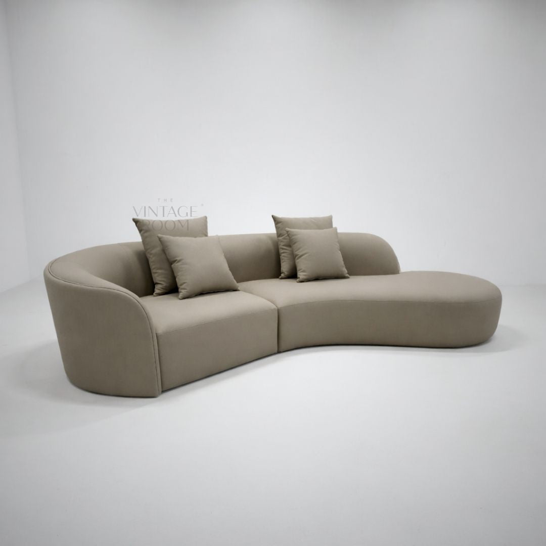 Loungesofa Aurielle i premium tekstil med matchende puder og afrundet lounge-ende til moderne stue